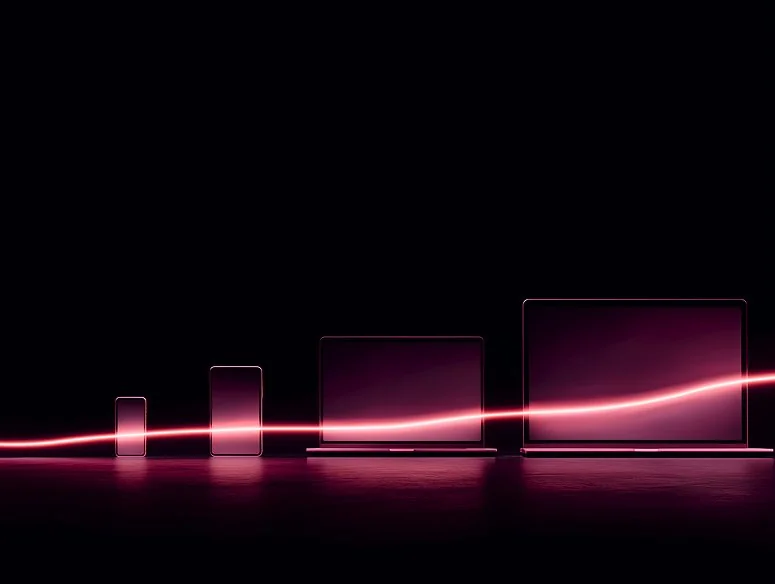 Row of devices in ascending size, smartphone, tablet, laptop, and desktop monitor, silhouetted against a black background with a glowing pink light wave flowing across them.