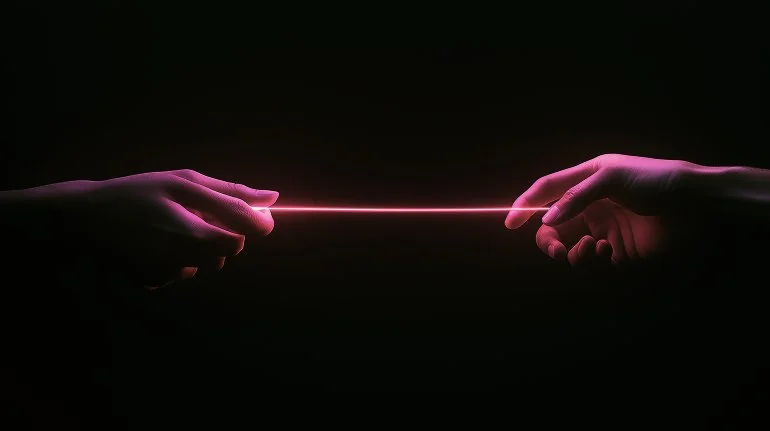 Two hands reaching toward each other from opposite sides with a glowing pink horizontal line connecting their fingertips against a dark background.